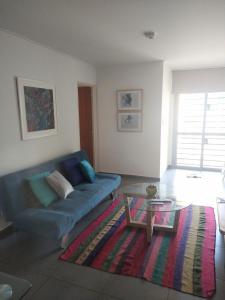 sala de estar con sofá azul y mesa en Habitat Plaza en Córdoba