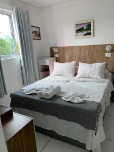 a bedroom with a large bed with towels on it at Flat Manamar in Porto De Galinhas