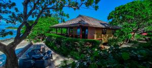 una casa en la playa con un banco y un árbol en Moorea Golf Lodge en Maharepa