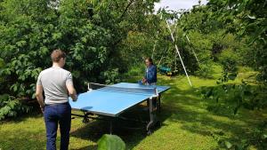 a man and a woman standing around a ping pong table at Appart indépendant, 1 lit deux personnes et 1 appoint Piscine Jardin Direct Gare Aéroport et jardin in Toulouse