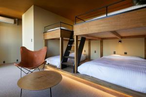 a bedroom with bunk beds and a chair and a table at mizuka Nakasu 5 - unmanned hotel - in Fukuoka