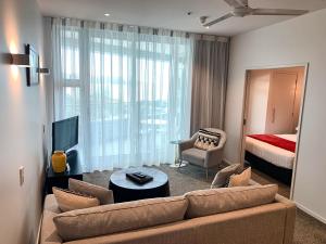 a living room with a couch and a bed at Marsden Suites Nautilus Orewa in Orewa