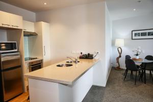 a kitchen with a sink and a counter top at Marsden Suites Nautilus Orewa in Orewa