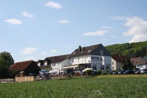 a large white building in a town with a grass field at Landgasthaus Hesse in Hameln