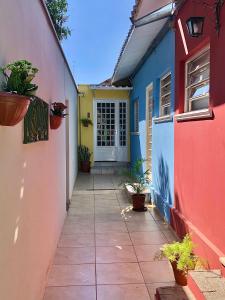 a walkway leading to a colorful house with plants at Casa com ótima localização in Piracicaba