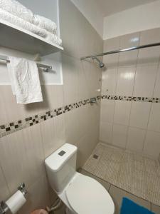 y baño blanco con aseo y ducha. en Micro Hotel Express, en San Pedro Sula
