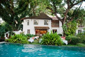a house with a swimming pool in front of a house at Old Harbour Hotel in Cochin