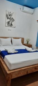 um quarto com uma cama de madeira com lençóis azuis e brancos em Turtle Island Homestay em Sanur