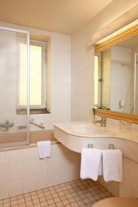 W białej łazience znajduje się umywalka i lustro. w obiekcie Hotel Adler w mieście Greifswald