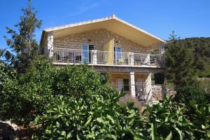a house on a hill with trees in front of it at Apartment Josipa in Vis
