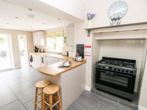 a kitchen with a stove and a counter with stools at Pondfield Gate in Garnant