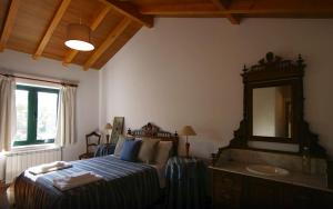 a bedroom with a bed and a mirror and a sink at Beautiful house and garden at Serra da Estrela, perfect for groups and families in Gouveia