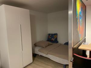 ein kleines Schlafzimmer mit einem Bett und einem Schrank in der Unterkunft Haus Friedel 2 in Überlingen