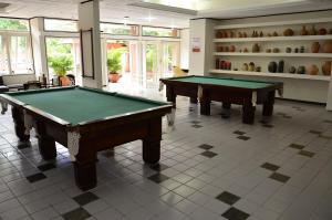 two pool tables in a room with windows at Aimberê Eco Resort Hotel in Coqueiro