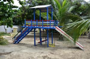 a playground with blue and red chairs on the beach at Aimberê Eco Resort Hotel in Coqueiro