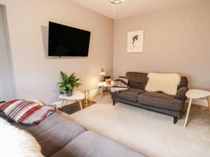 a living room with a couch and a flat screen tv at Water Street in Aberaeron