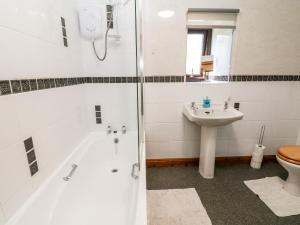 a bathroom with a shower and a toilet and a sink at Keepers Cottage in Chapel en le Frith +14 photos