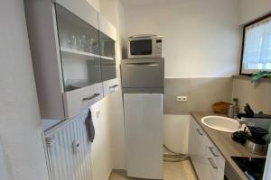 uma pequena cozinha com um lavatório e um micro-ondas em Apartment Harzblick -NEU MODERNISIERT- em Sankt Andreasberg