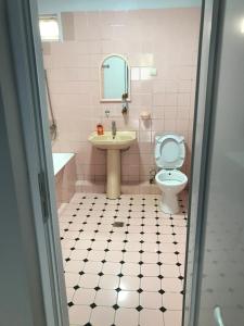 Baño rosa con lavabo y aseo en Bubu's Home, en Batumi