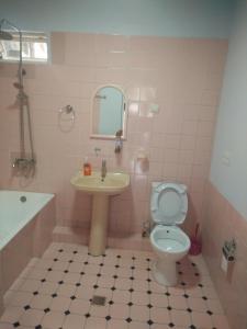 Baño rosa con lavabo y aseo en Bubu's Home, en Batumi