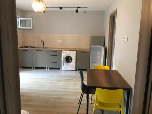 cocina con mesa de comedor y sillas amarillas en Bubu's Home, en Batumi 4 fotos más