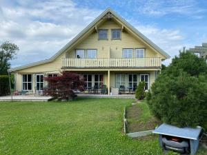 a large yellow house with a porch and a yard at Ferienhaus Norway in Wittenbeck