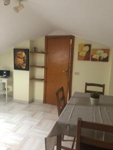 a dining room with a table and a wooden door at Appartamentino Mansardato in Pedara +12 photos