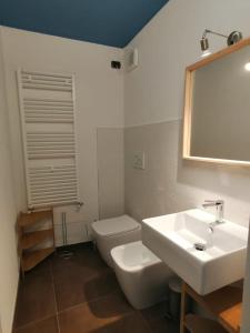 a bathroom with a sink and a toilet and a mirror at Albergo della Posta in Mondovì