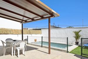 um pátio com uma mesa e cadeiras e uma piscina em Casa Jaime em Conil de la Frontera