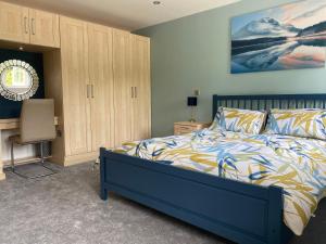 a bedroom with a bed and a desk and a chair at Relaxing Retreat Around Nature in Wrexham