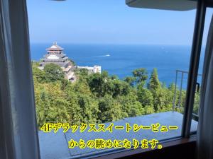 a view from a train window of a building at Mujuan in Atami