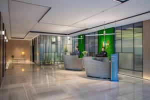 a lobby with two people sitting at a desk in a building at EVEN Hotel Shenzhen Nanshan by IHG in Shenzhen