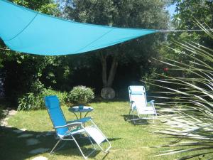 ヴィック・ラ・ガルディオルにあるChambres d'hôtes Lou Félibreの庭に芝生の椅子3脚とテーブル