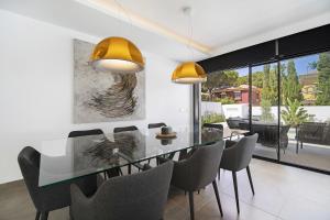 una sala da pranzo con tavolo in vetro e sedie di Manuela Sea Villa a Chiclana de la Frontera