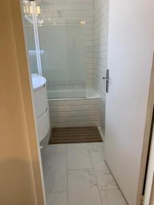 a white bathroom with a tub and a shower at Appart T3 kodjo in Pessac