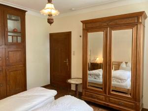 um quarto com um grande armário de madeira e 2 camas em Hinkelshof em Körperich