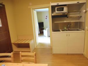 a small kitchen with a sink and a microwave at Auberge De Launay in Limeray