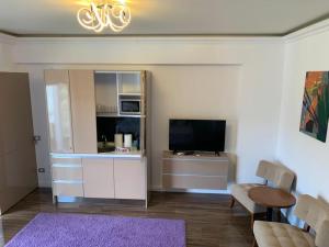 a living room with a tv and a couch and a table at White Tower Mamaia Prestige Apartments in Mamaia