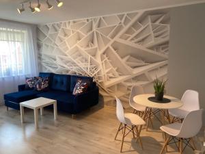 uma sala de estar com um sofá azul e mesas em Blue Apartment close to Old Town em Bydgoszcz