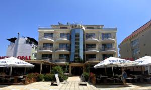 ein großes Gebäude mit Sonnenschirmen davor in der Unterkunft Hotel Opal in Primorsko
