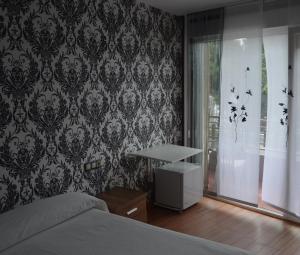 a bedroom with a bed and a wall with wallpaper at Hostal Solymar in Louro +105 photos