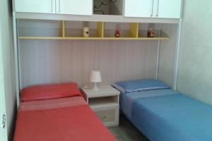 a bedroom with two beds and a table with a lamp at Otranto selva del turchese in Otranto +15 photos