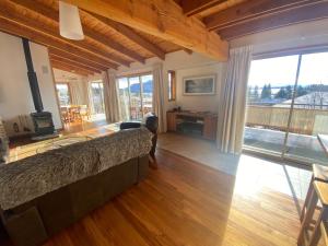 um quarto com uma cama e uma grande janela em Glacier Rock Lakeview House em Lake Tekapo