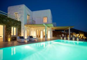 a swimming pool in front of a villa at night at Ammos Villas in Fanari