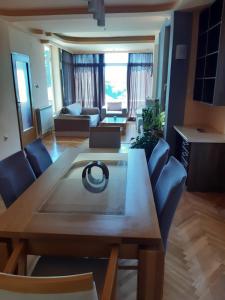 a living room with a wooden table and blue chairs at IVAN Apartment in Peštani