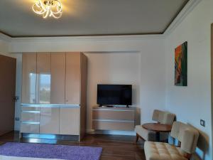 a living room with a television and a table and chairs at White Tower Mamaia Prestige Apartments in Mamaia