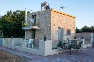 a house with a balcony with a table and chairs at Mini Bella Gonia in Gonia
