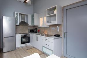 a kitchen with white cabinets and a refrigerator at Mini Bella Gonia in Gonia