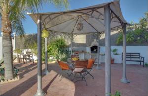 een patio met een parasol en een tafel en stoelen bij Cortijo VILLA EL PINO in Torrox