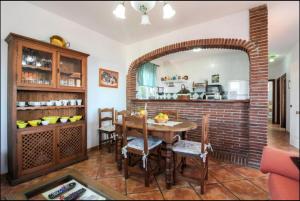 een eetkamer met een tafel en een bakstenen muur bij Cortijo VILLA EL PINO in Torrox